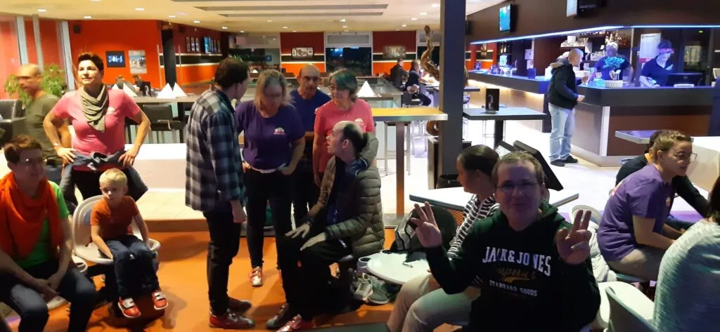 Un groupe de personnes assises dans une piste de bowling.