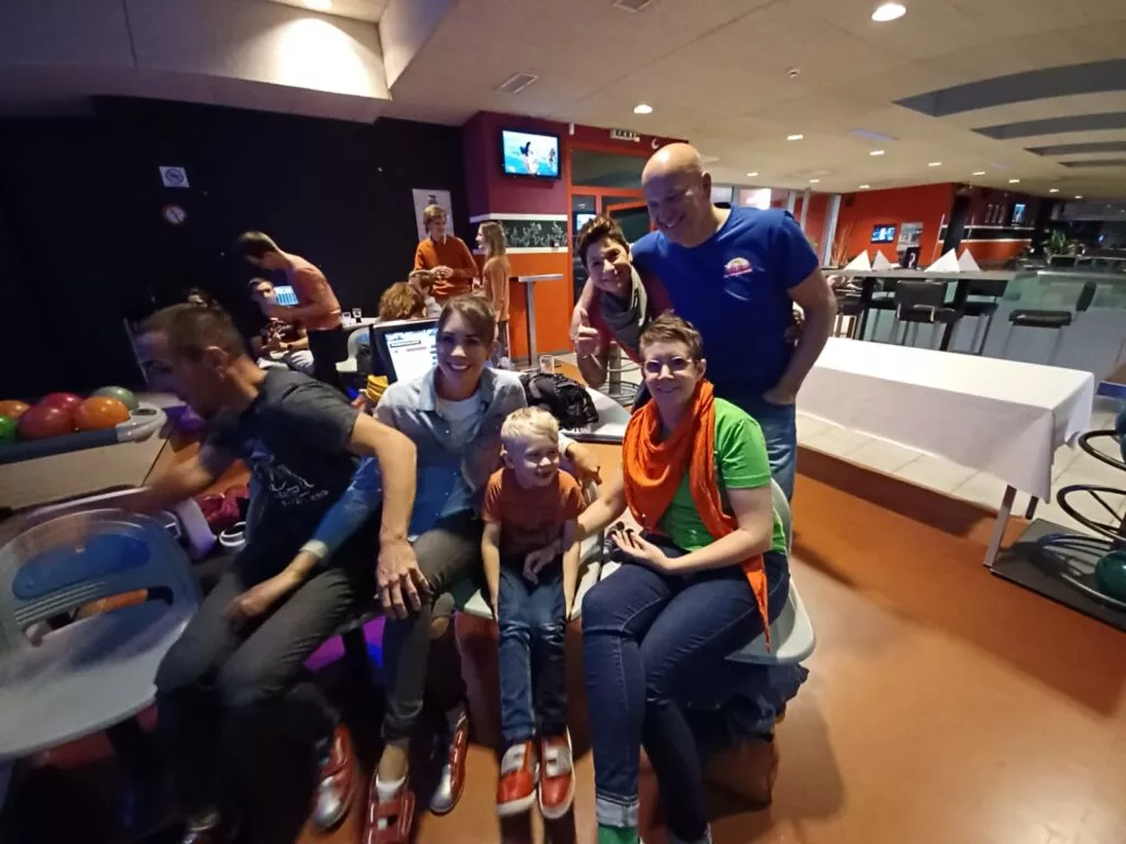 Un groupe de personnes posant pour une photo dans une piste de bowling.
