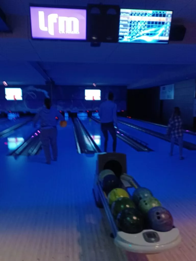 Un bowling avec des gens qui jouent au bowling.