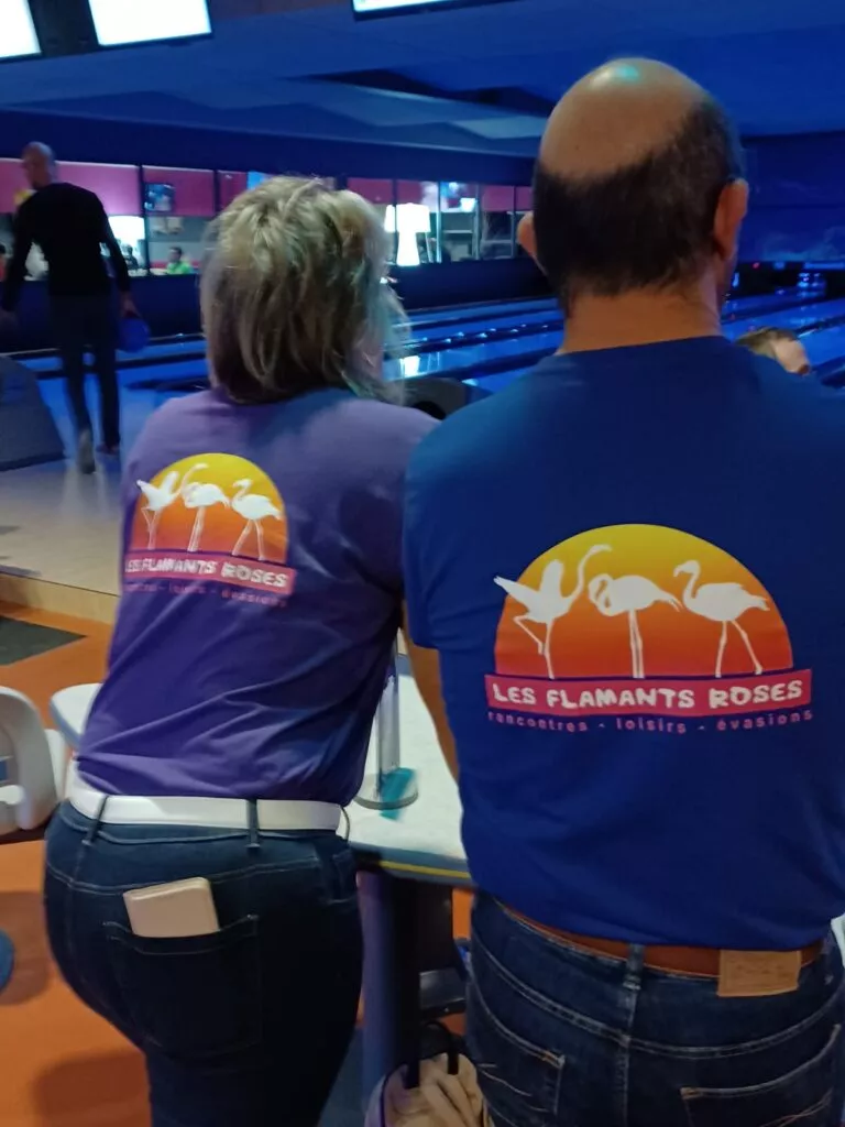 Deux personnes portant des chemises de bowling dans une piste de bowling.