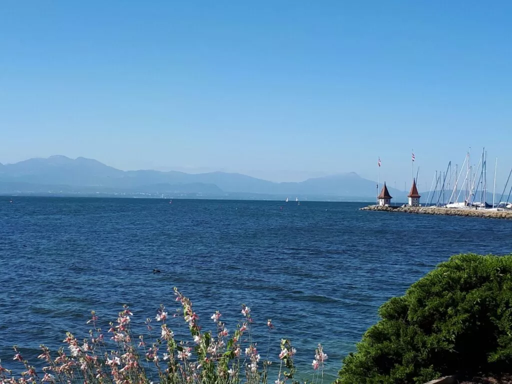 Un bateau amarré dans l'eau avec des montagnes en arrière-plan.