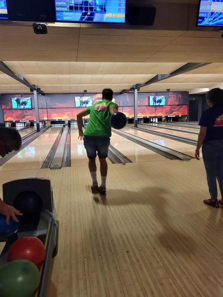Un groupe de personnes jouant au bowling dans une piste de bowling.