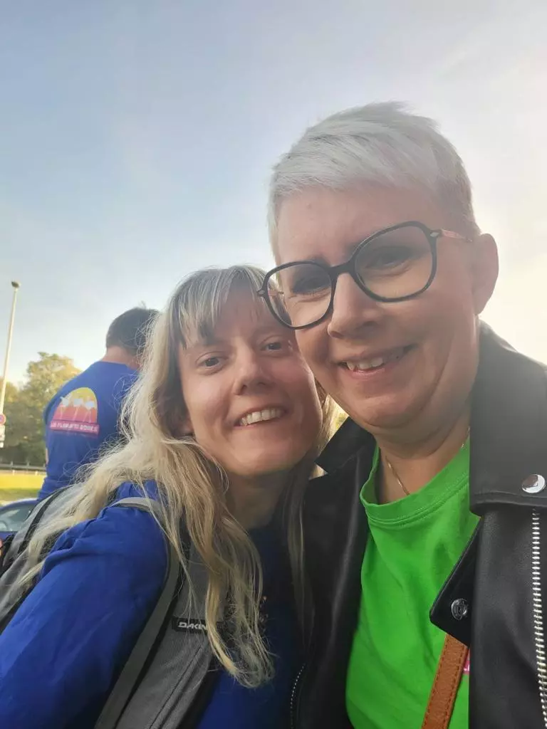 Deux femmes posant pour une photo dans un parking.