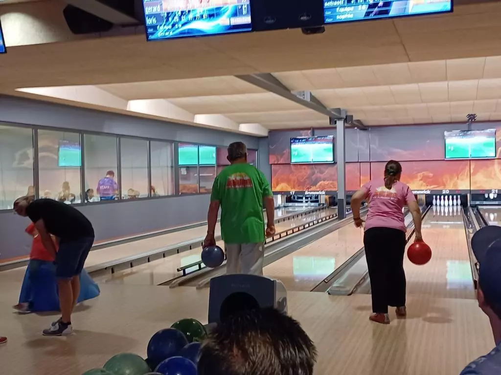 Un groupe de personnes jouant au bowling dans une piste de bowling.