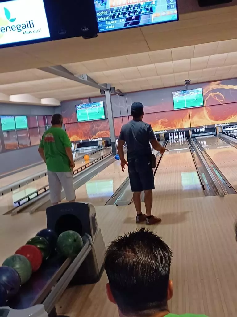 Un groupe de personnes jouant au bowling dans une piste de bowling.