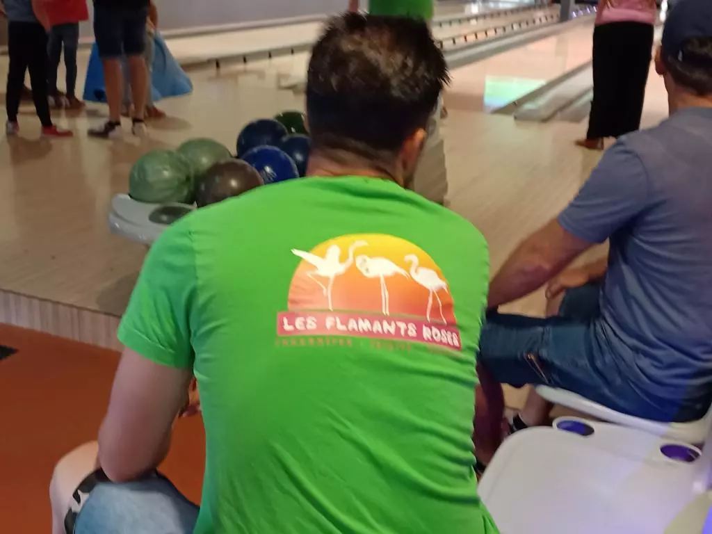 Un groupe de personnes jouant au bowling dans une piste de bowling.