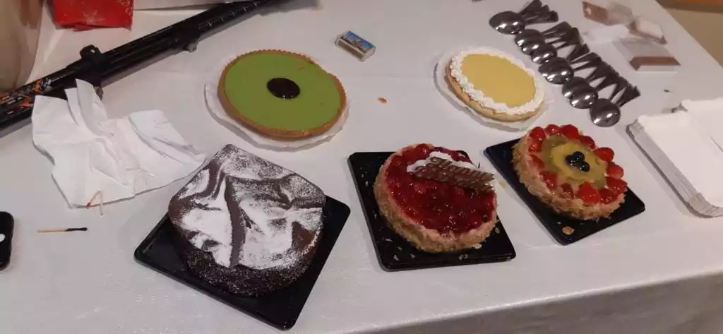 Une table avec plusieurs gâteaux et un pistolet dessus.