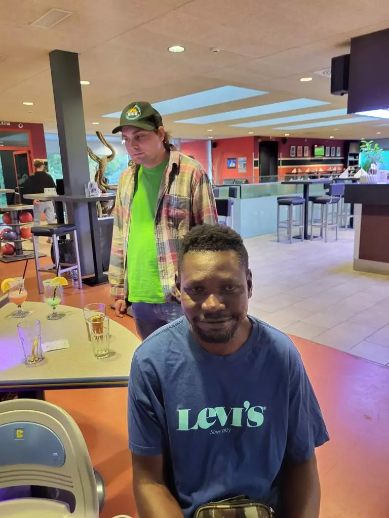 Deux hommes assis à une table dans un bowling.