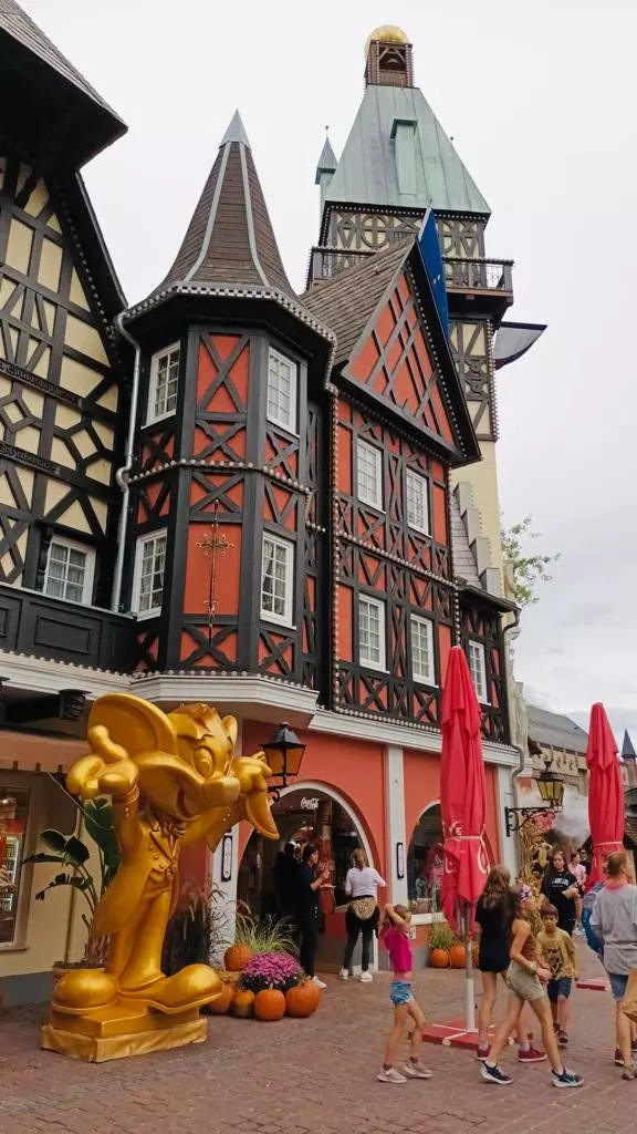 Un groupe de personnes marchant devant un bâtiment doté d’une tour d’horloge.