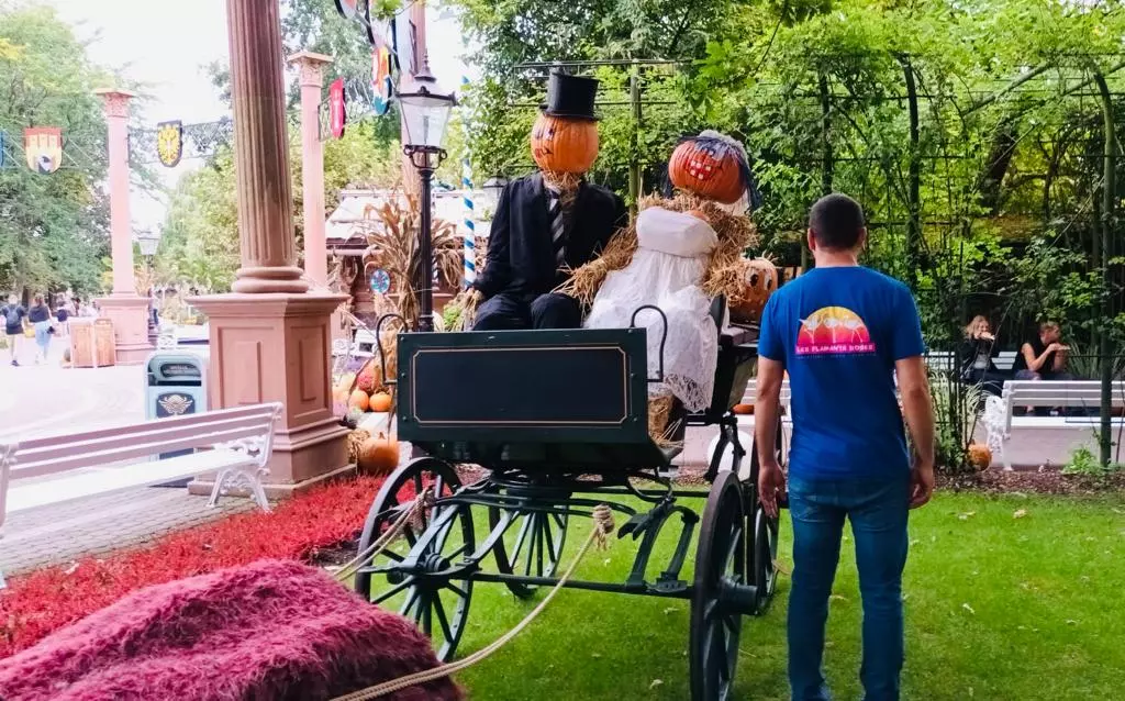 Un couple dans une calèche avec des citrouilles en arrière-plan.