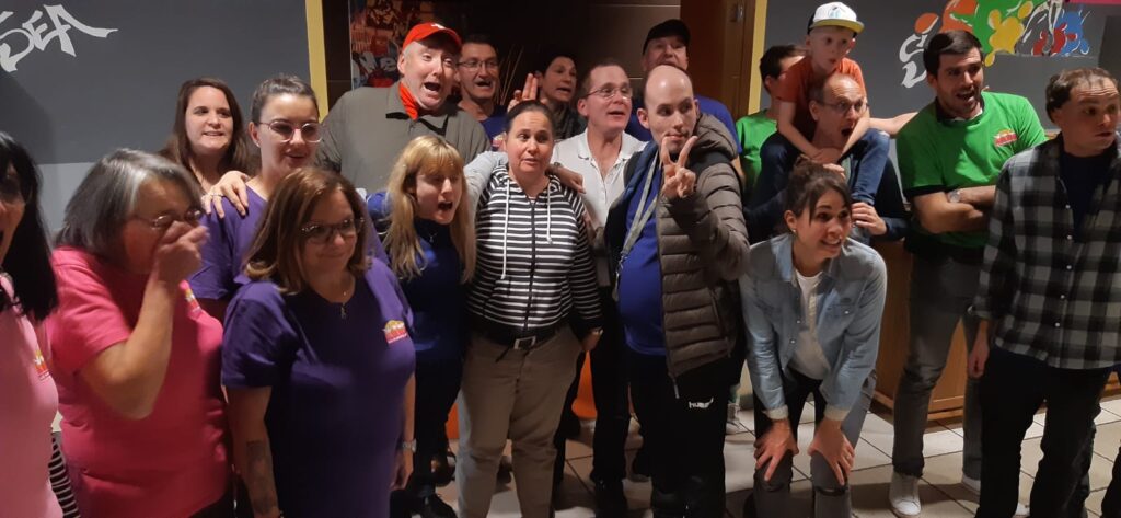 Un groupe de personnes debout devant un tableau.