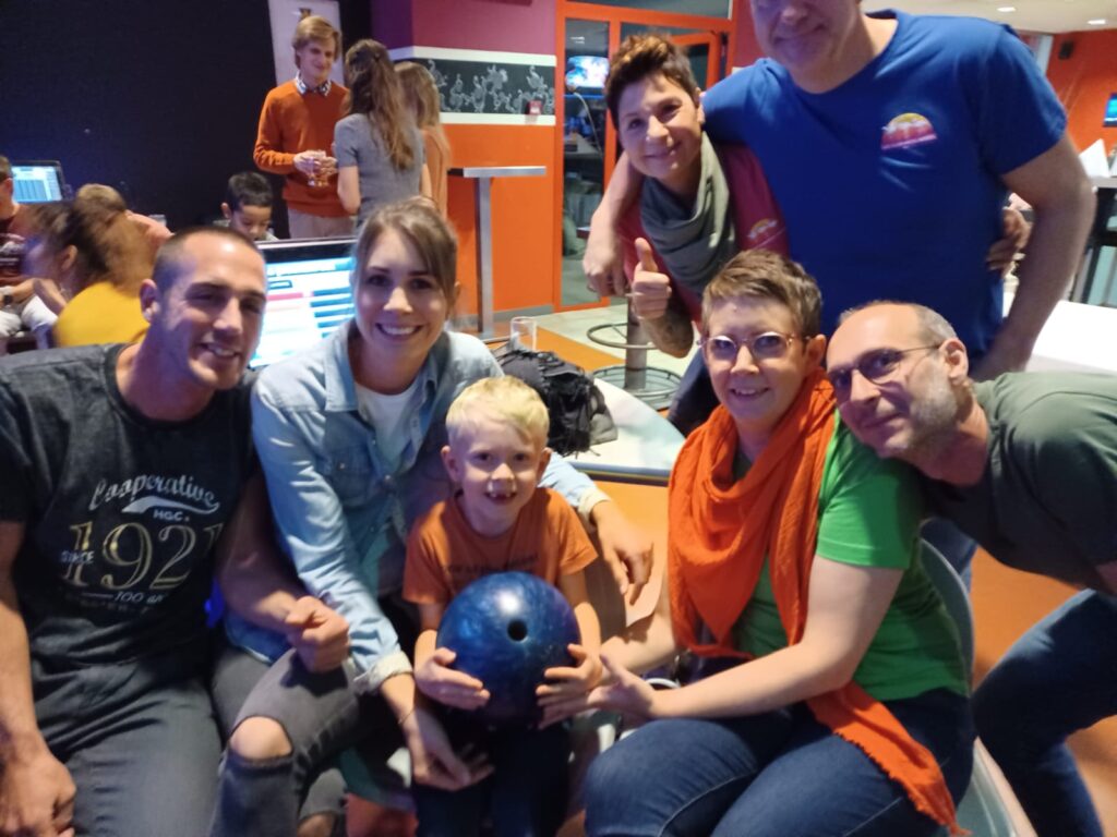 Un groupe de personnes posant pour une photo dans une piste de bowling.