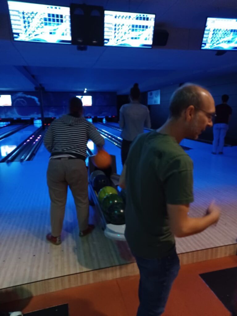 Un homme jouant au bowling dans une piste de bowling.