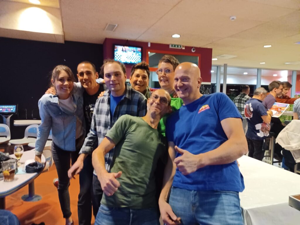 Un groupe de personnes posant pour une photo dans une piste de bowling.