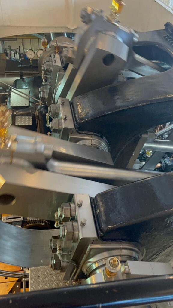 Vue rapprochée d'une grande machine industrielle avec des composants métalliques, des boulons et des jauges, présentant des pièces mécaniques complexes et des détails d'ingénierie.